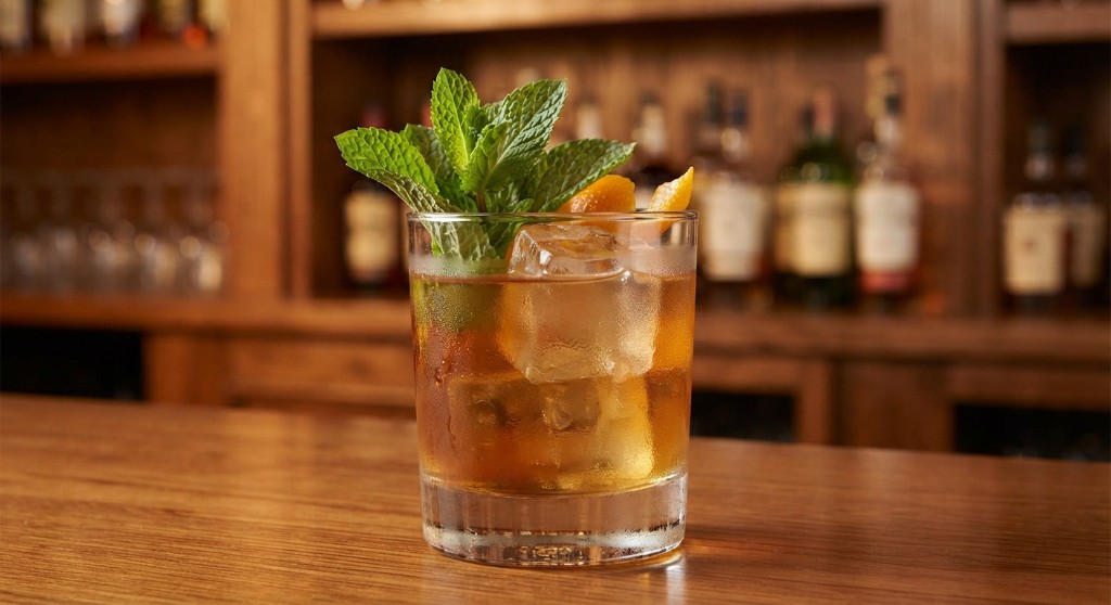 Rocks cocktail garnished with mint and orange peel